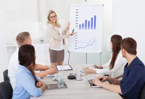 A picture of a woman presenting some important graphs