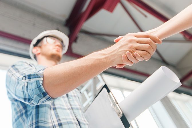 A picture of a contractor shaking his hand with a client